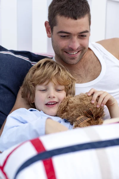 Porträt von Vater und Sohn beim Lesen eines Buches im Bett — Stockfoto