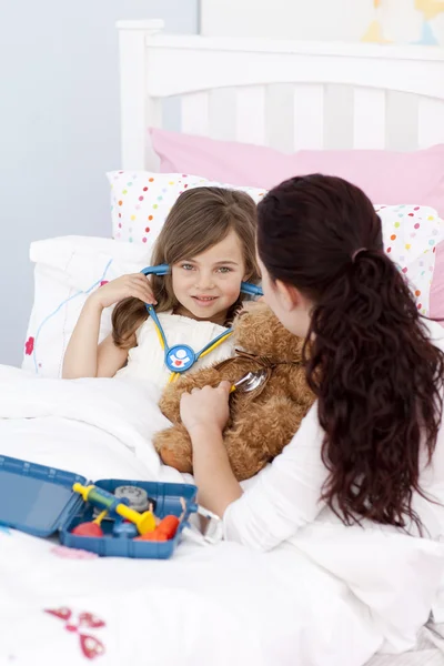 Kvinna och liten flicka spelar med stetoskop — Stockfoto
