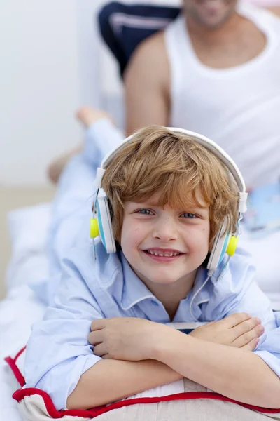 Portret van een kleine jongen, luisteren naar muziek in de slaapkamer — Stockfoto