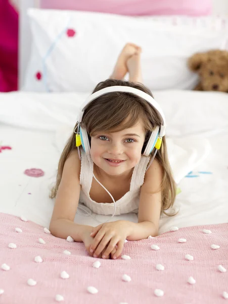 听音乐在床上的小女孩 — 图库照片