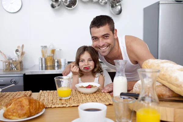 Dochter granen en fruit eten in keuken — Stockfoto
