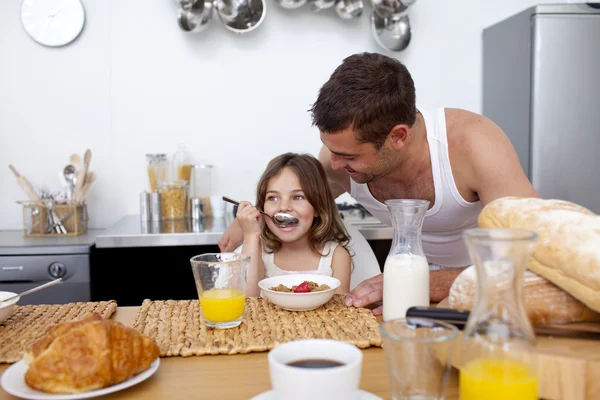 Daughter eating cereals and fruit for breakfast — Stock Photo, Image