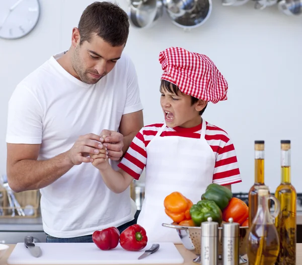 Boy cut his finger in kitchen and father treating it — Stock Photo, Image