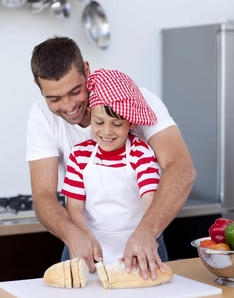 Man and little boy cutting bread — Stock Photo, Image