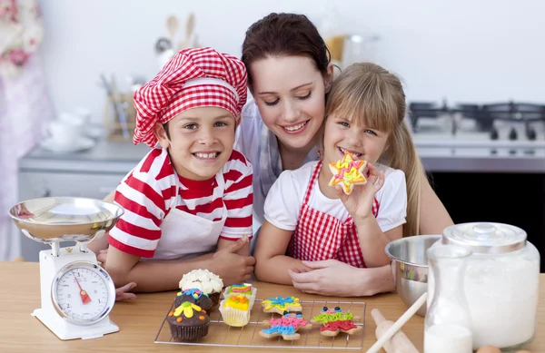 Mãe sorridente e crianças assando na cozinha — Fotografia de Stock