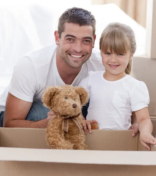 Père et fille avec un ours en peluche déménageant à la maison — Photo