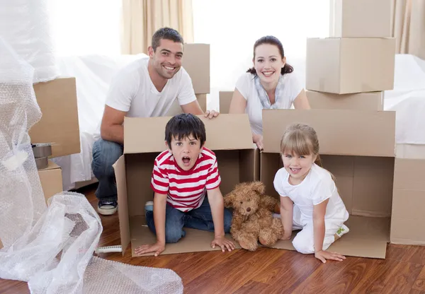 Família movendo casa com caixas ao redor — Fotografia de Stock