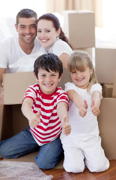 Famiglia in movimento casa con scatole e pollici in su — Foto Stock