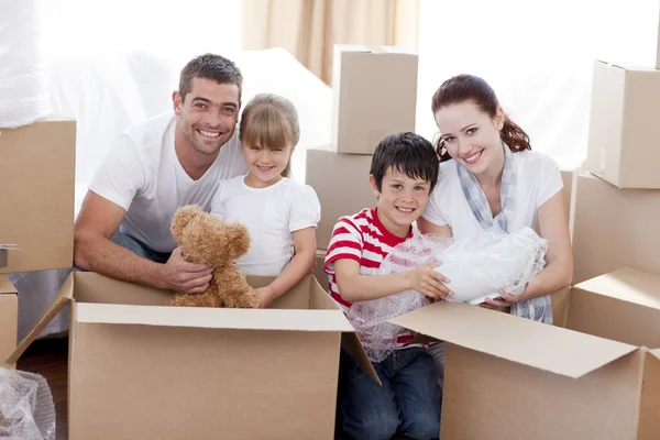 Família se mudando para casa com caixas ao redor — Fotografia de Stock