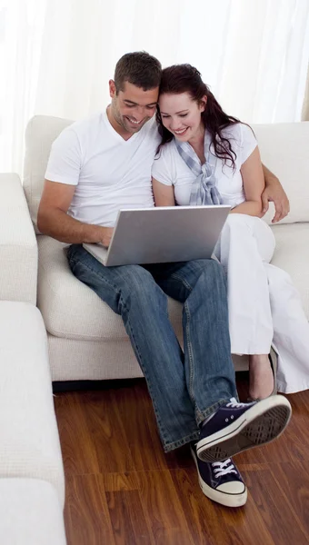夫妇在沙发上使用一台笔记本电脑 — 图库照片