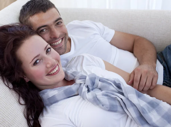 Couple souriant couché sur le canapé — Photo