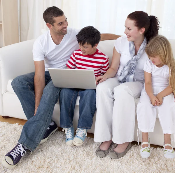 Smiling family in living-room using a laptop — Stock Photo, Image