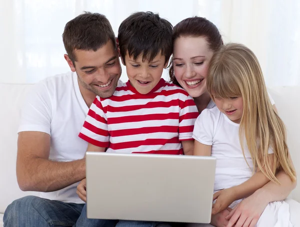 Famille à la maison jouer avec un ordinateur portable — Photo