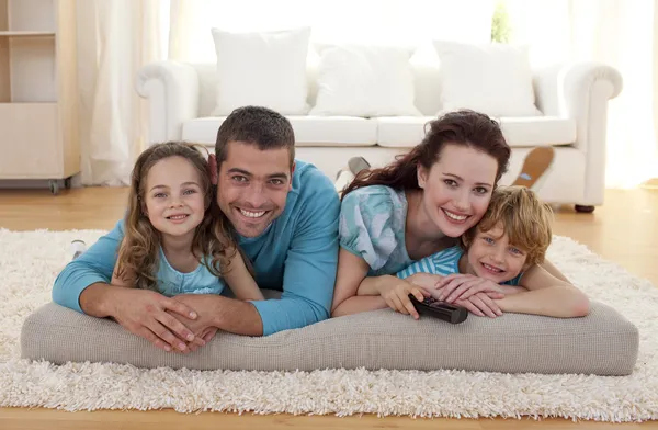 Familia sonriente en el suelo en la sala de estar —  Fotos de Stock