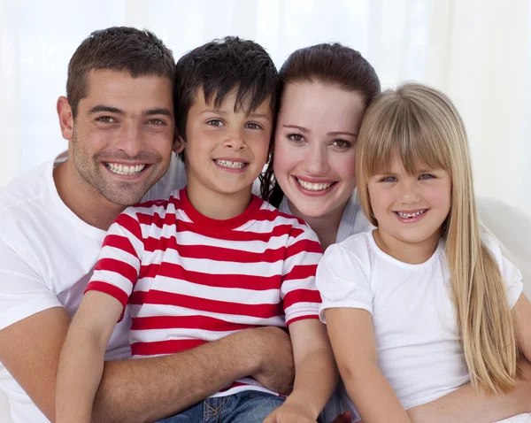 Portrait of happy family sitting on sofa together — Stock Photo, Image
