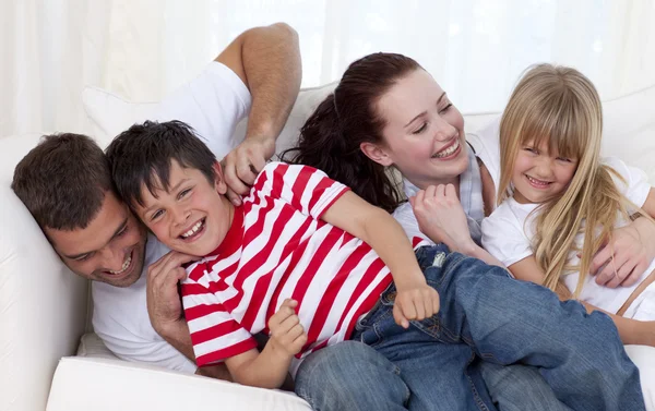 Perhe leikkii sohvalla yhdessä — kuvapankkivalokuva