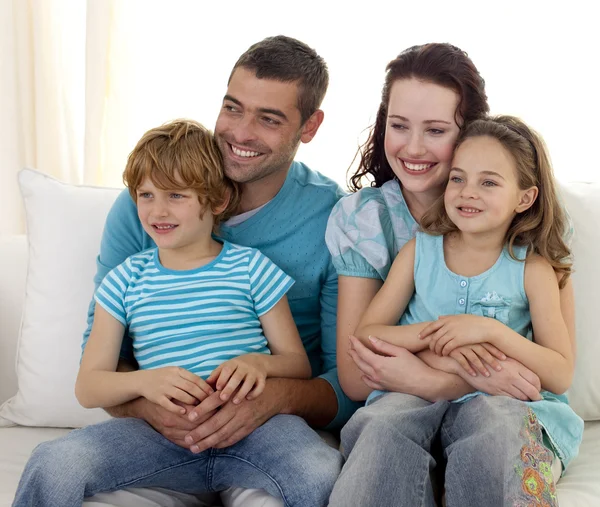 Rodzina siedzi na kanapie, oglądanie telewizji — Zdjęcie stockowe