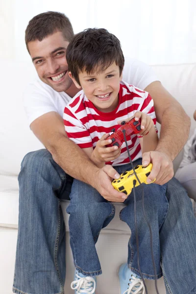 Усміхнений батько і дитина грають у відеоігри вдома — стокове фото