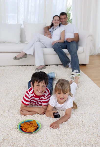 Ευτυχισμένα παιδιά παρακολουθώντας τηλεόραση στον όροφο και στο καθιστικό — Φωτογραφία Αρχείου