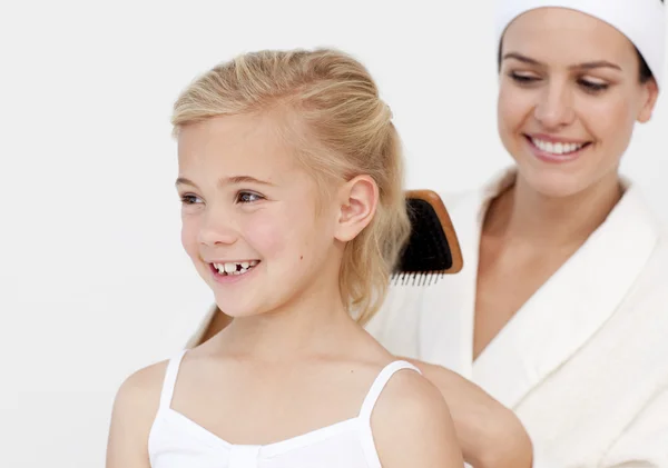 Young mother doing daughter's hair — Stock Photo, Image