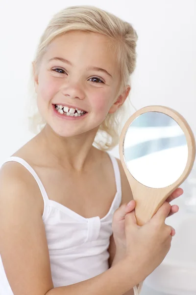 Little girl playing holding a mirror — Stock Photo, Image
