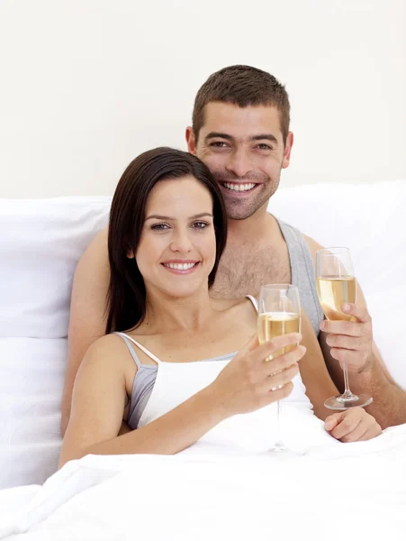 Para pitnej szampana w łóżku — Zdjęcie stockowe