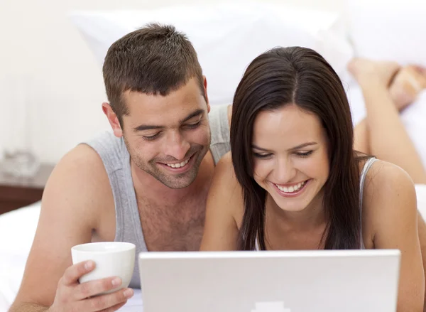 Couple au lit s'amuser avec un ordinateur portable — Photo