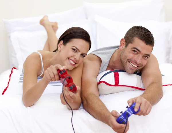 Ζευγάρι παίζοντας βιντεοπαιχνίδια στο κρεβάτι — Φωτογραφία Αρχείου