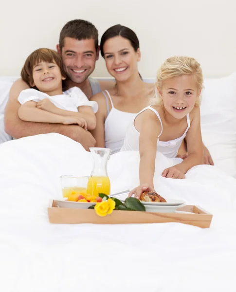 Föräldrar och barn som äter frukost i sovrum — Stockfoto