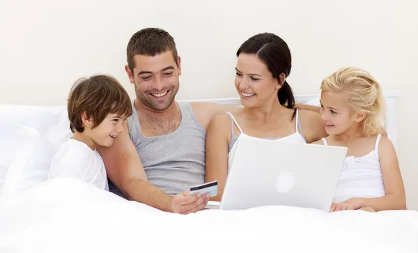 Familie kauft online im Bett ein — Stockfoto