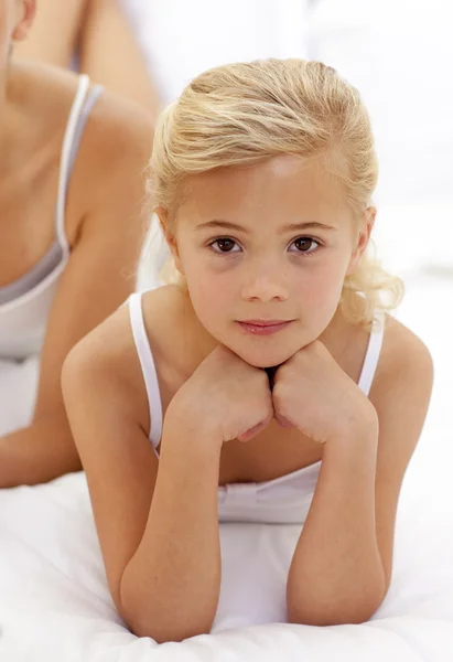 Porträt eines kleinen Mädchens, das auf dem Bett liegt — Stockfoto