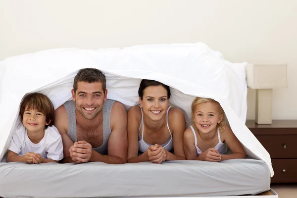 Happy family under the sheets — Stock Photo, Image