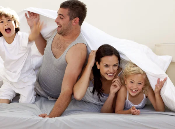 Семья веселится в родительской постели — стоковое фото