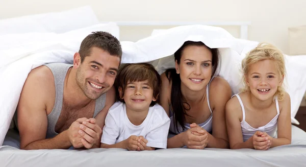 Rodina hraje v posteli rodičů — Stock fotografie