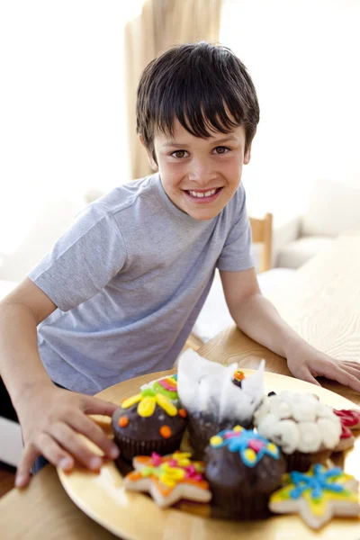 カラフルなお菓子を食べて幸せな少年 — ストック写真