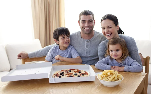Familie eten van pizza en frietjes thuis — Stockfoto