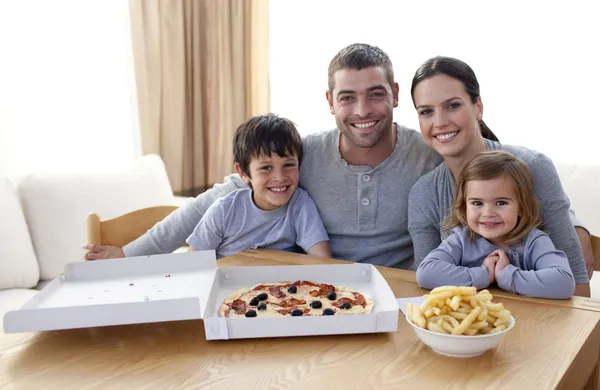 Rodina jíst pizzu a hranolky doma — Stock fotografie