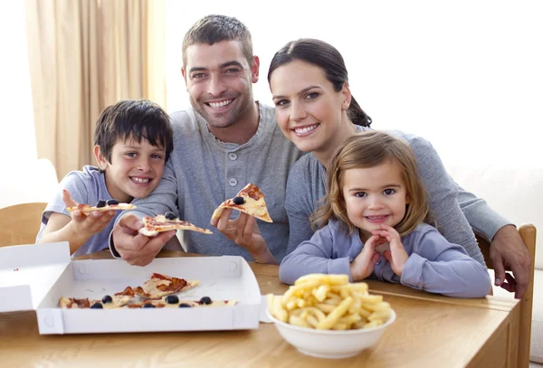 Pais e crianças comendo pizza e batatas fritas em casa — Fotografia de Stock