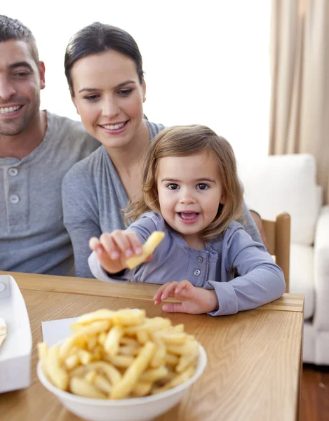 Liten flicka äter pommes frites hemma — Stockfoto