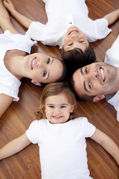 Familjen liggande på golvet med huvuden tillsammans — Stockfoto