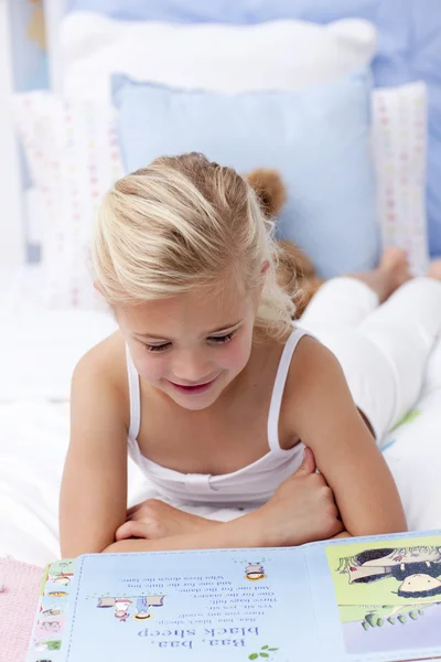 Κοριτσάκι, διαβάζοντας ένα βιβλίο στο κρεβάτι — Φωτογραφία Αρχείου