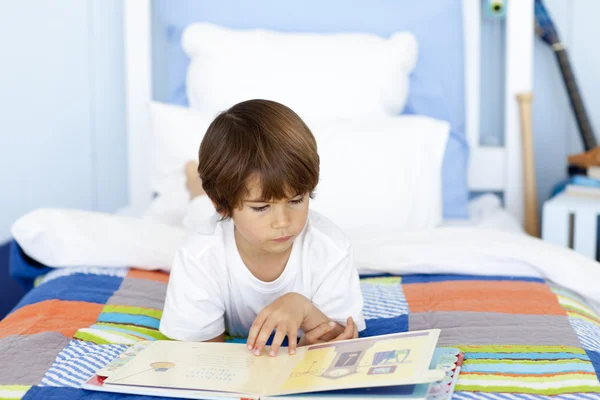 Мальчик читает в постели — стоковое фото
