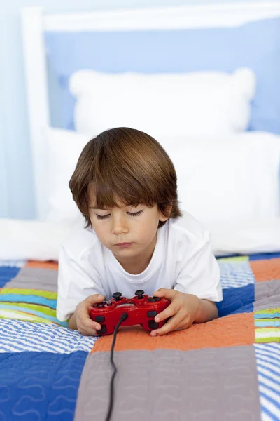 彼の寝室でビデオゲームをしている少年 — ストック写真