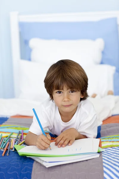 Retrato de menino desenho na cama — Fotografia de Stock
