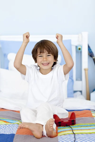 Lycklig pojke spelar videospel i sovrum — Stockfoto