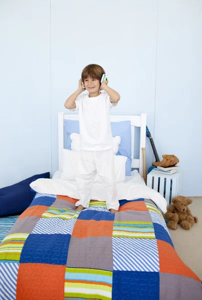 Kleiner Junge hört Musik und tanzt im Schlafzimmer — Stockfoto