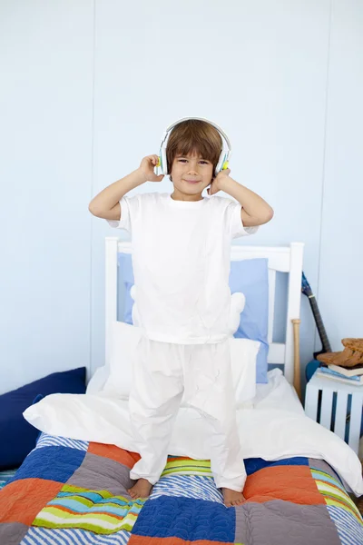 Kleiner Junge mit Kopfhörern tanzt im Schlafzimmer — Stockfoto