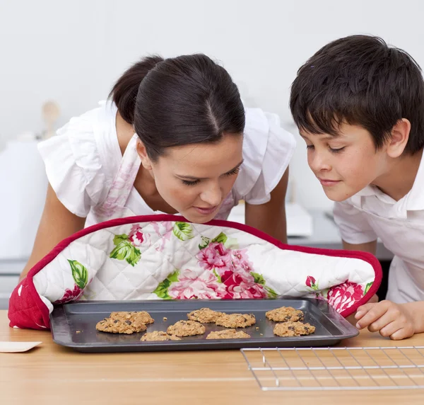 Mãe e filho cheirando biscoitos caseiros — Fotografia de Stock