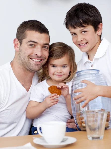 Ojciec i dzieci jedzenie ciastka z mlekiem — Zdjęcie stockowe