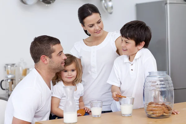 Rodiče a děti jíst sušenky a konzumní mléko — Stock fotografie